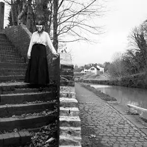 masked figure on steps near canal