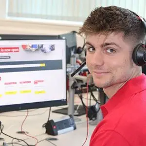 man with headset sat in front of a computer