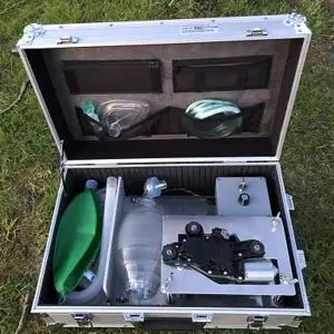 Open equipment case containing tubing, masks and components for a portable field ventilator.