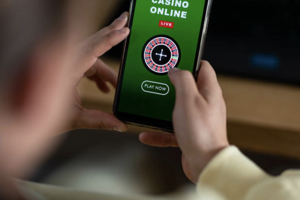 Hands holding a mobile phone with an online casino game on the screen 
