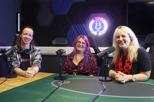 Three people sat in a podcast recording studio