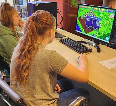 Two girls playing the Ecopolis game on a computer