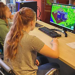 Two girls playing the Ecopolis game on a computer