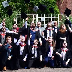 Computer games graduates and staff throwing their hats in the air
