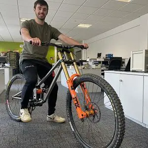 Man sat astride a bicyle in an engineering lab