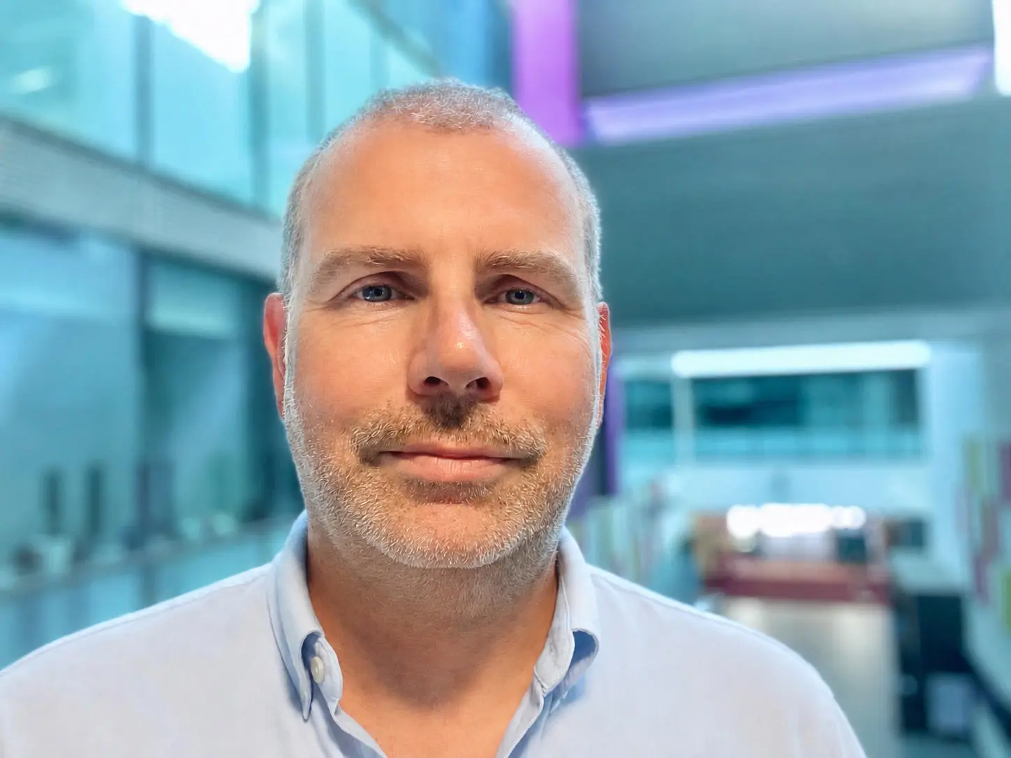 A head and shoulders image of a middle aged man looking at the camera