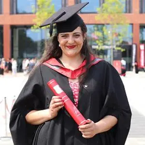 Jasmine Barton in her graduation robes holding a scroll