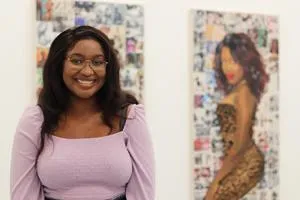 Jioni Warner standing in front of her artwork