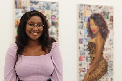 Jioni Warner standing in front of her artwork