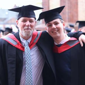 Kelvin and Chris pictured in their graduation robes