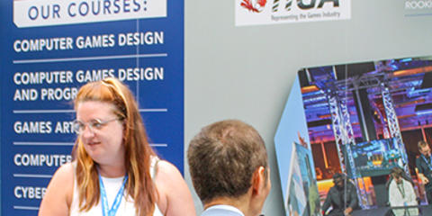 A female and male engaging with prospective students at a recruitment fair.