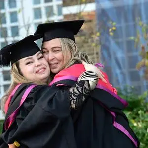 Female graduates hugging
