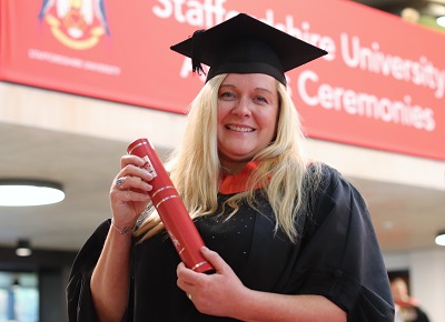 Lisa Wood holding a scroll in her graduation gown