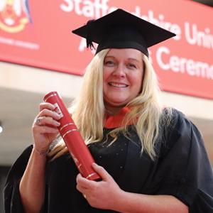 Lisa Wood holding a scroll in her graduation gown