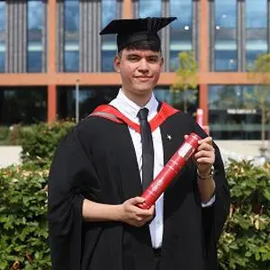 Lucas Ulitschnik in his graduation robes holding a scroll
