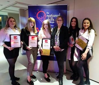 Five women hold plaques and certificates at the National Skills Challenge event.