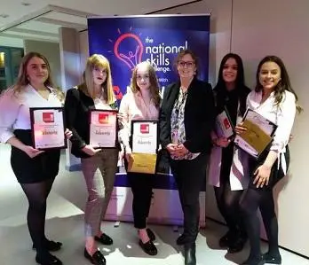 Five women hold plaques and certificates at the National Skills Challenge event.