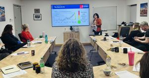 classroom of people facing a digital screen