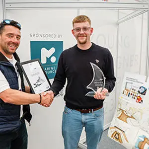 Ollie Rommelrath being presented with the Superyacht UK Young Designer trophy