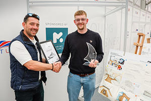 Ollie Rommelrath being presented with the Superyacht UK Young Designer trophy