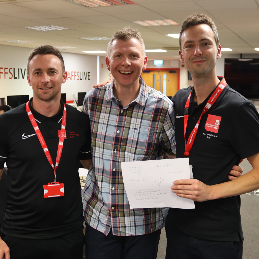 Three men standing together and smiling