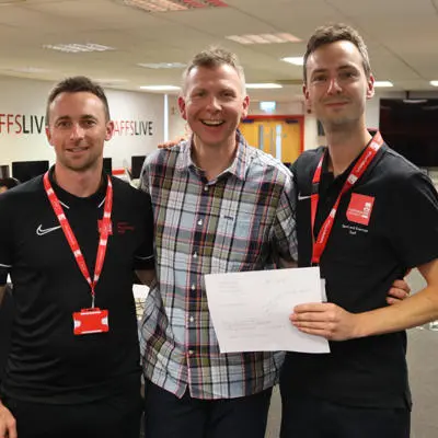 Three men standing together and smiling
