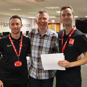 Three men standing together and smiling