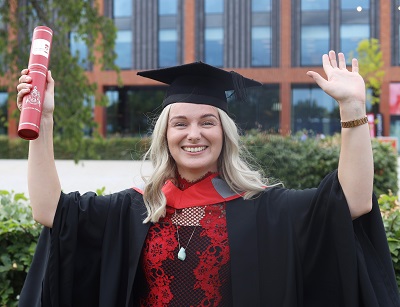 Philippa Bourne in her graduation robes holding a scroll