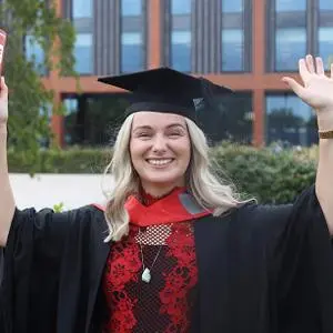 Philippa Bourne in her graduation robes holding a scroll