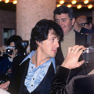 A young Sylvester Stallone surrounded by photographers