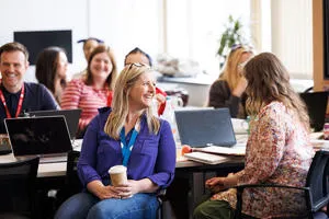 A group of adults smiling in a classroom setting