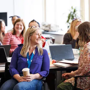 A group of adults smiling in a classroom setting