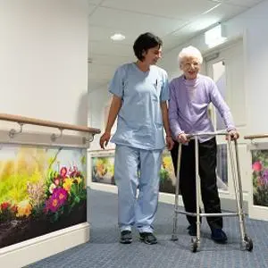 Nurse and patient walking through care home