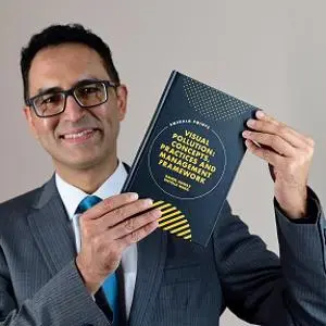 Head and shoulders pic of man holding a text book.