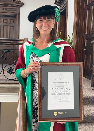Dr Rachel Bolton-King holding her Outstanding Alumni Award certificate