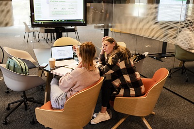 Two female students sat in meeting room