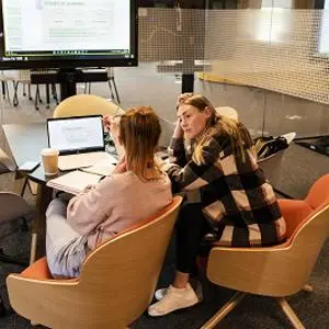 Two female students sat in meeting room
