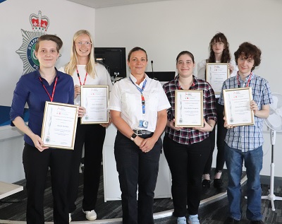 Group of students stood holding their certificates presented by Assistant Chief Constable