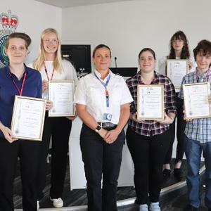 Group of students stood holding their certificates presented by Assistant Chief Constable