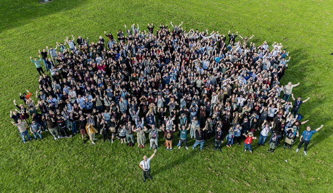 An aerial photo of a large group of people with their hands in the air