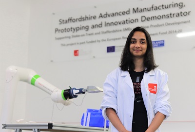 Student Shruti photographed next to a robotic arm
