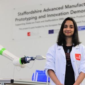 Student Shruti photographed next to a robotic arm