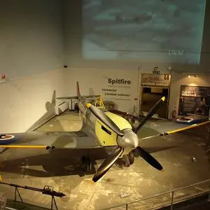 Spitfire aircraft displayed in a museum gallery with information panels around it.