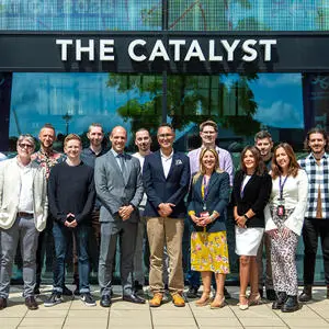 A large group of people in front of a building, underneath a sign that reads 'The Catalyst'
