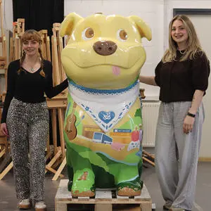 Students Grace Jones and Amy Watkins stood either side of a decorated Staffy Staffordshire Bull Terrier sculpture
