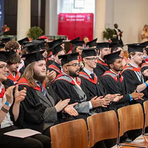 Staffordshire University London graduates wearing caps and gowns