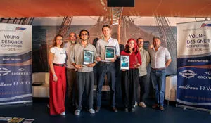 A group of seven people with three holding framed certificates