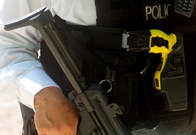 A close up image of a police officer armed with a taser