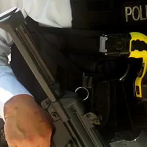A close up image of a police officer armed with a taser