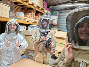 Taylor Smith (right) and course mates in beekeeping suits
